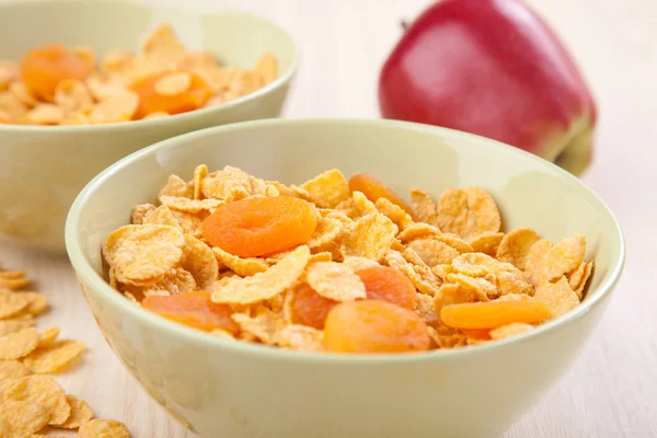 Green bowls of crunchy corn flakes for breakfast with apple on w — Stock Photo, Image