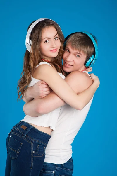 Joven pareja de amor. Niño sosteniendo chica. usar auriculares — Foto de Stock