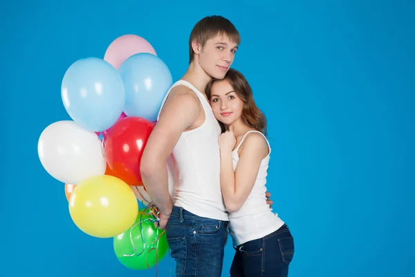 Lachende jonge liefde paar houden diversicolored ballonnen — Stockfoto