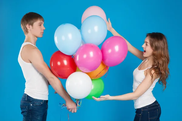 Jonge jongen ballonnen presenteren aan een meisje. — Stockfoto