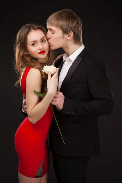 Beautiful elegant love couple wearing suit and red dress with wh — Stock Photo, Image