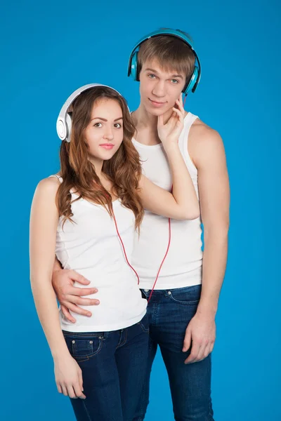 Young love couple. Boy holding girl. wearing headphones, listeni — Stock Photo, Image