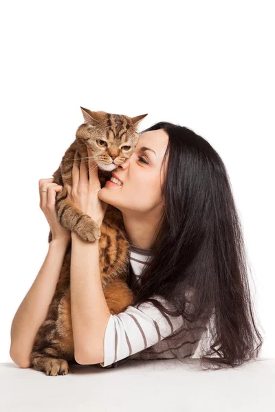 Krásná usměvavá brunetka a její kočičí nad bílým ba — Stock fotografie
