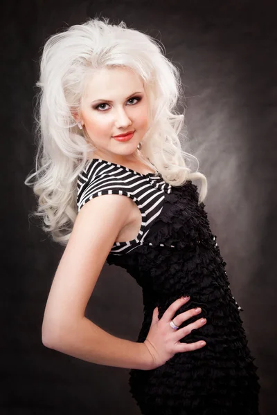 Studio shot of a young, beautiful, blonde woman in black dress — Stock Photo, Image