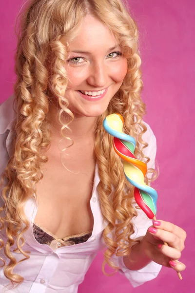 Blonde curly girl smiling holding big lollipop — Stock Photo, Image