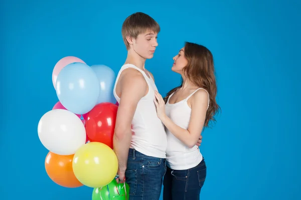 Leende ung kärlek par hålla ballonger i studion — Stockfoto