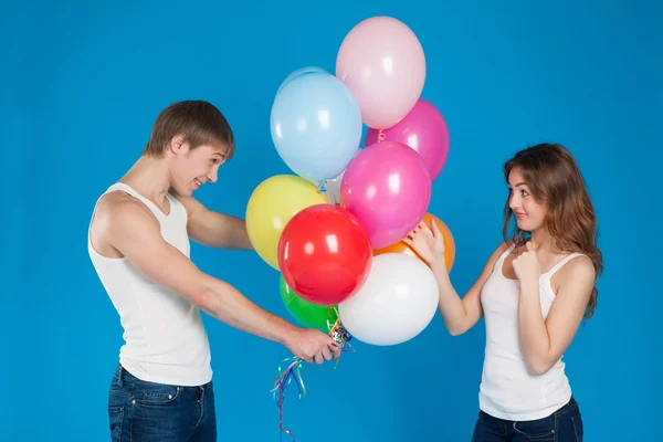 Lachende jonge liefde paar ballonnen houden in de studio — Stockfoto