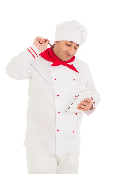 Sorridente cozinheiro segurando caderno e caneta, pensando , — Fotografia de Stock