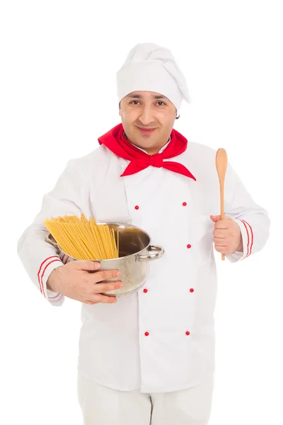 Sonriente cocinero sosteniendo la sartén llena de macarrones crudos usando wh — Foto de Stock