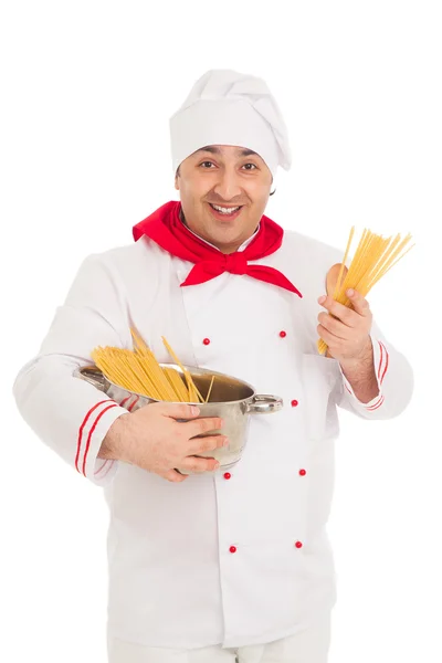 Smiling cook man holding pan filled with raw macaroni wearing wh — Stock Photo, Image