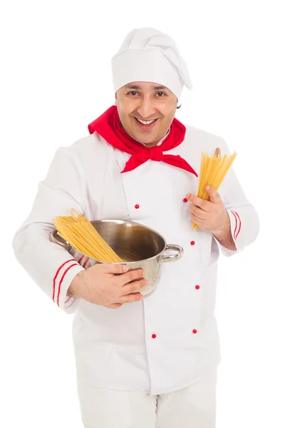 Smiling cook man holding pan filled with raw macaroni wearing wh — Stock Photo, Image