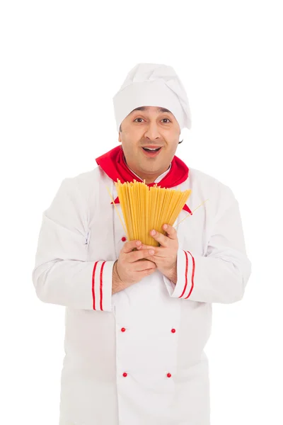 Cocinero vistiendo uniforme blanco sosteniendo macarrones crudos — Foto de Stock