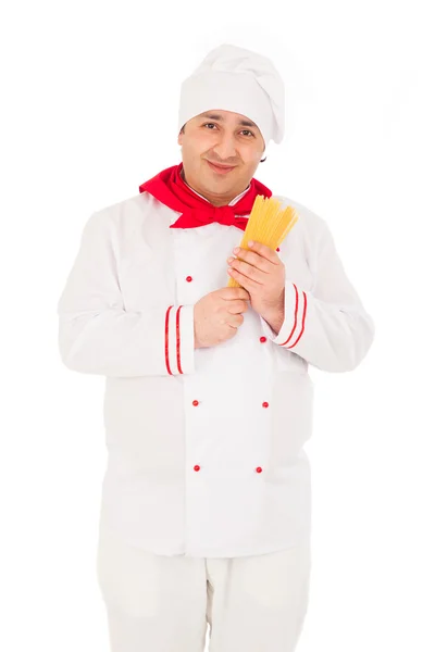 Smiling cook man wearing white uniform holding raw macaroni in t — Stock Photo, Image
