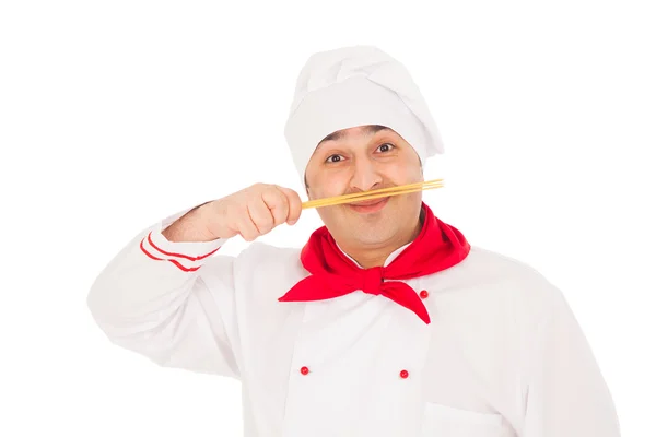 Smiling cook man wearing white uniform holding raw macaroni as m — Stock Photo, Image