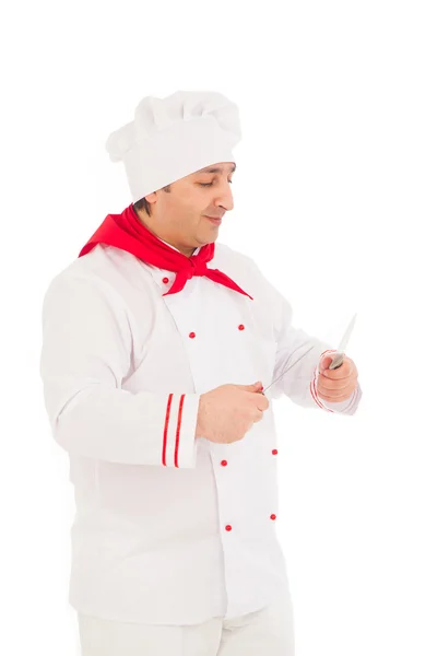 Smiling chef holding two knifes wearing red and white uniform — Stock Photo, Image