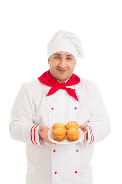 Chef segurando placa com muffins vestindo uniforme vermelho e branco — Fotografia de Stock