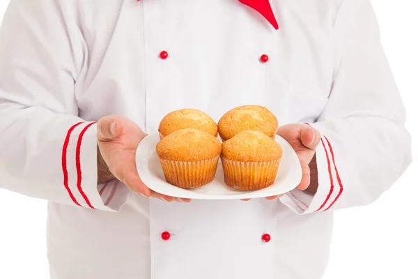 Chef segurando placa com 4 muffins vestindo uniforme vermelho e branco — Fotografia de Stock