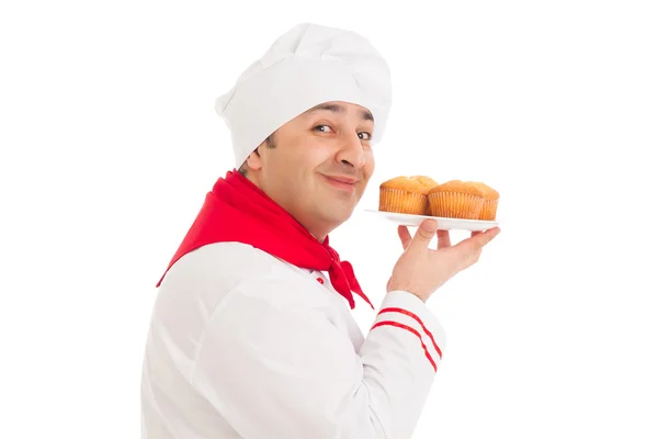 Chef segurando placa com 4 muffins vestindo uniforme vermelho e branco — Fotografia de Stock