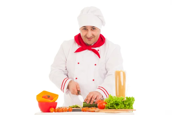 Cuoco felice cucina con verdure fresche indossando rosso e bianco — Foto Stock