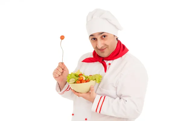 Шеф-повар держит блюдо с салатом и свежими овощами в красном — стоковое фото