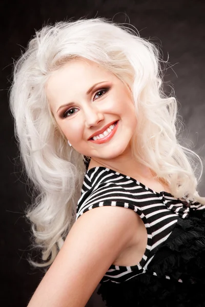 Studio shot of a young, beautiful, blonde woman in black dress — Stock Photo, Image