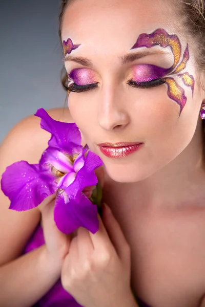 Beautiful girl with bright make-up holding purple iris — Stock Photo, Image