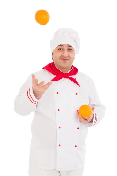 Happy chef holding two oranges wearing red and white uniform — Stock Photo, Image