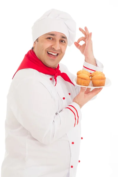 Happy chef holding plate with 4 muffins wearing red and white un — Stock Photo, Image