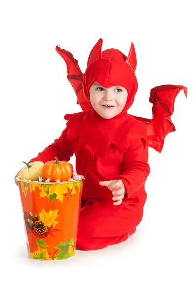 Niño pequeño con traje de diablo rojo sentado cerca de un cubo grande —  Fotos de Stock