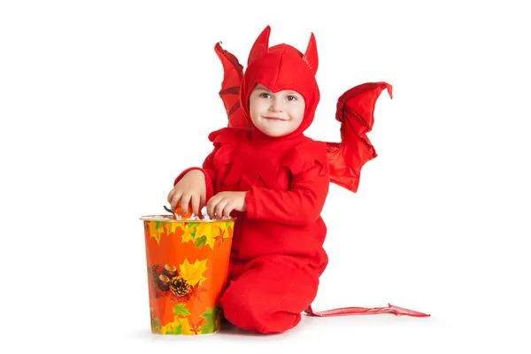 Kleine jongen in rode duivel kostuum zitten in de buurt van grote emmer — Stockfoto