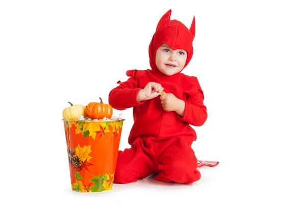 Niño pequeño con traje de diablo rojo sentado cerca de un cubo grande —  Fotos de Stock