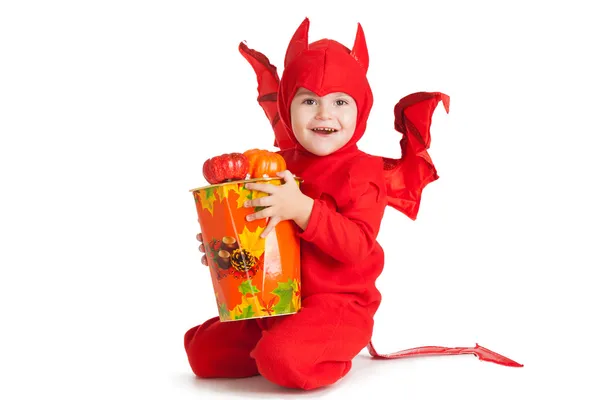 Niño pequeño con traje de diablo rojo sentado cerca de un cubo grande —  Fotos de Stock