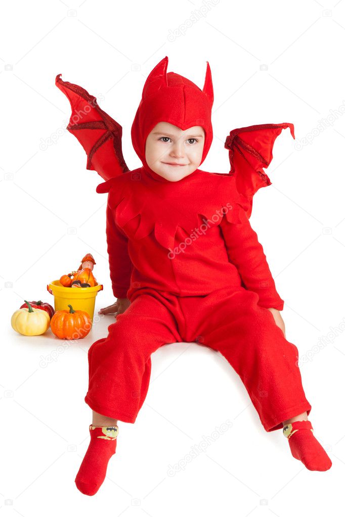 little boy in red devil costume sitting with pumpkins