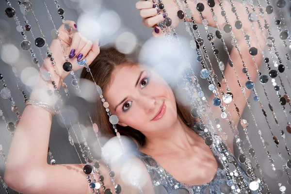 Fille avec des ongles violets en robe argentée tenant des perles — Photo