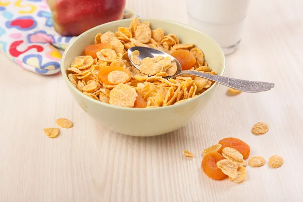 Green bowl of crunchy corn flakes for breakfast with apple on wo — Stock Photo, Image