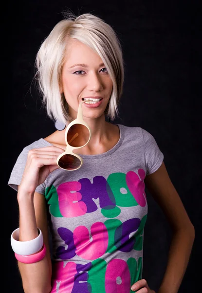 Blonde young woman holding sun-glasses in studio — Stock Photo, Image