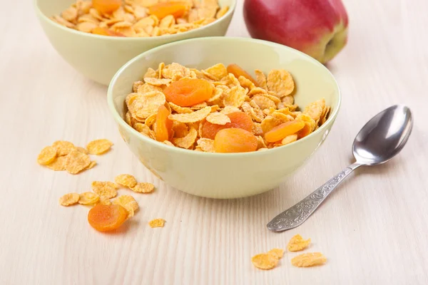 Green bowls of crunchy corn flakes for breakfast with apple — Stock Photo, Image