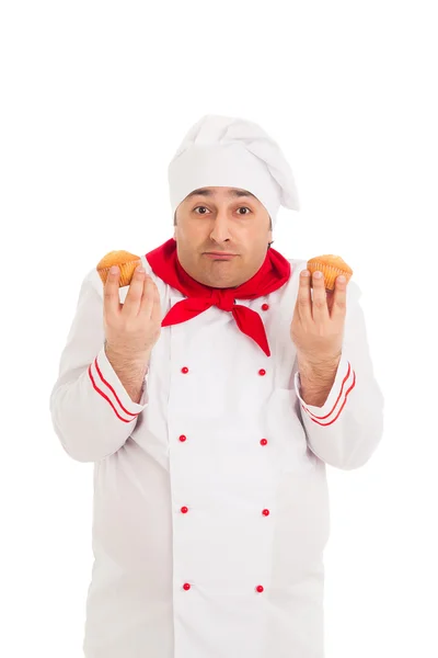 Chef emocional sosteniendo dos magdalenas con uniforme rojo y blanco — Foto de Stock