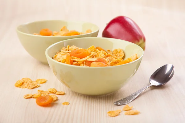 Green bowls of crunchy corn flakes for breakfast with apple on w — Stock Photo, Image