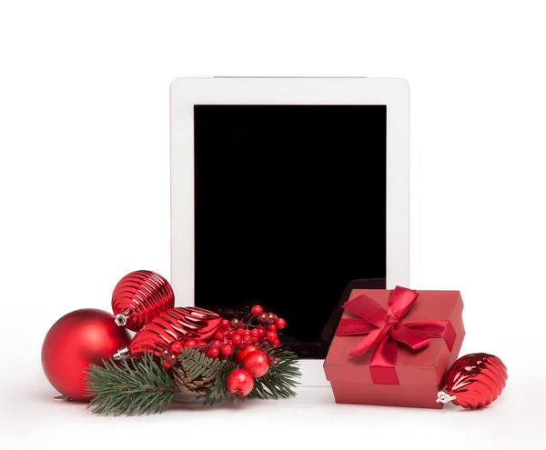 Tablet mit rotem Geschenkkarton und Weihnachtsbaumspielzeug Stockfoto
