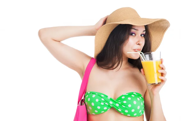 Brunette girl in green swimsuit and hat, holding  glass of juice — Stock Photo, Image