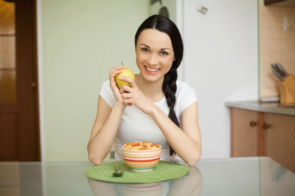 Brunettte girl having breakfast with muesli in the kitchen — Stock Photo, Image