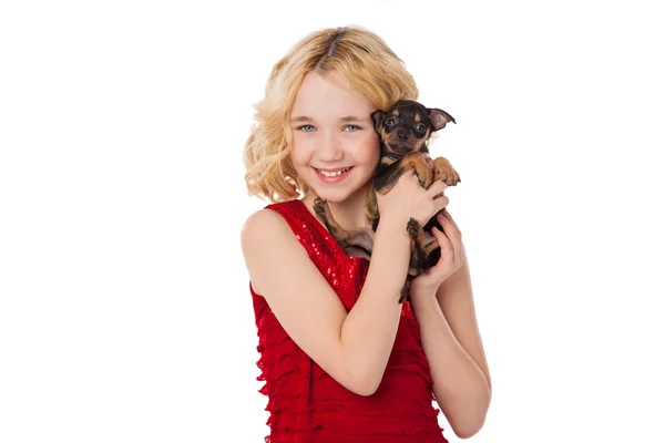 Szőke kislány gazdaság kiskutya visel piros ruha — Stock Fotó