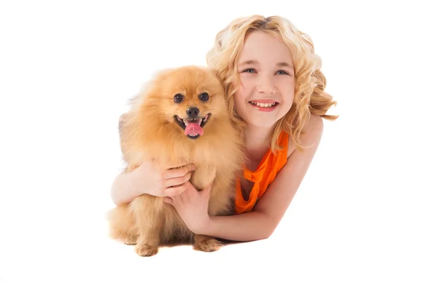 Pequena menina sorridente segurando seu cão — Fotografia de Stock