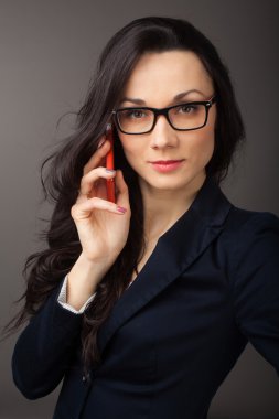 cep telefonuyla konuşurken ceket giymiş esmer kadın 