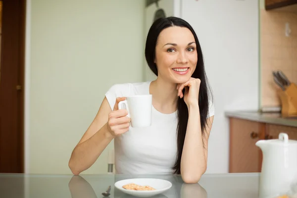 Mädchen trinkt morgens Tee mit Keksen — Stockfoto