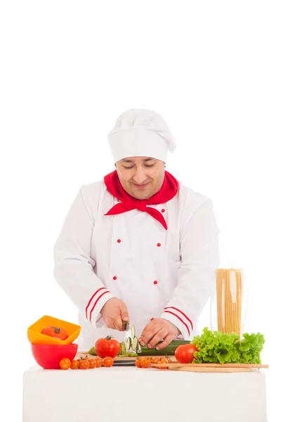 Cuoco felice cucina con verdure fresche indossando rosso e bianco — Foto Stock