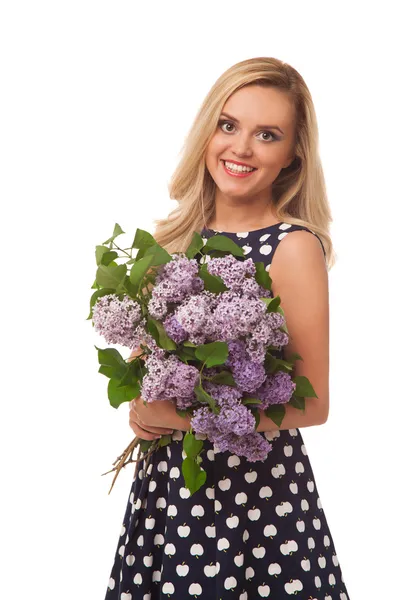 Blonde smiling girl in dot dress holding flower — Stock Photo, Image