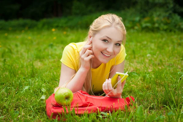 Flicka anläggning cell telefonerna och musik med vita hörlurar — Stockfoto