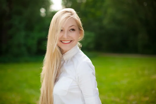 Девушка в парке с длинными светлыми волосами — стоковое фото